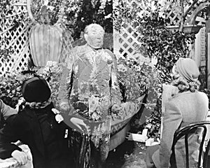 Man covered in mud standing in front of two ladies