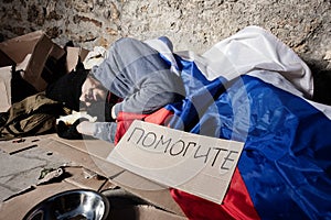 Man covered with Russian flag sleeping on street photo