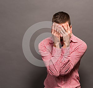 Man covering eyes his face