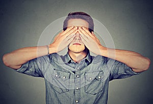 Man covering eyes with two hands