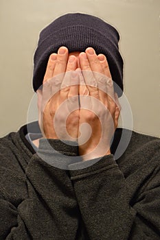 Man covering face with hands