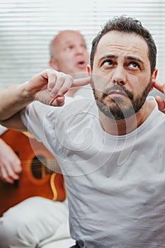 Man covering his ears against loud music