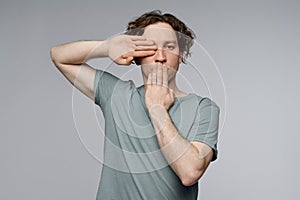 Man Covering His Eye And Mouth With Hands