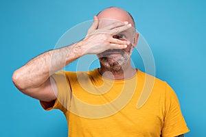 Man covering his face by hand, peeping trying to find put a top secret