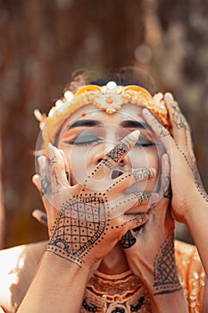 A Man covering his mouth with his hand while in golden accessories