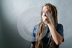 Man covering his mouth on a solid background
