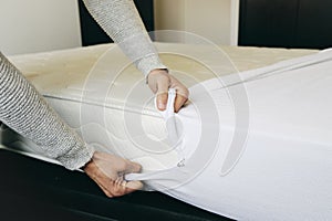 Man covering a mattress with a mattress protector photo