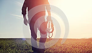 A man cowboy hat and a loso in the field. American farmer in a f