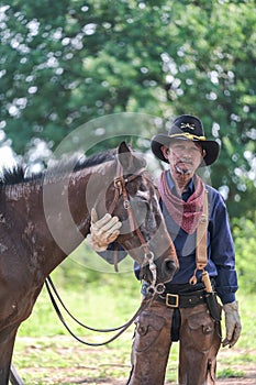 Man in a cowboy outfit with his horse