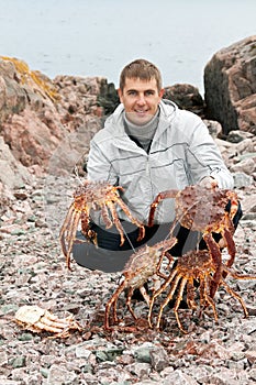 Man with crabs in the Barents Sea coast