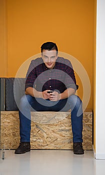 Man in crative box working on smart phone