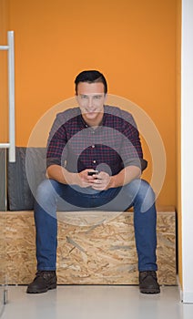 Man in crative box working on smart phone photo