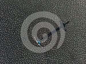 Man creating cross shadow on dry lake