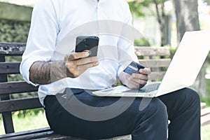 Man with credit card and mobile phone doing online payment