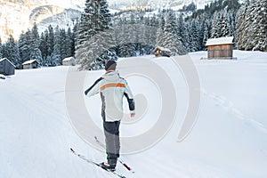 Man on cross country ski in snow covered mountains