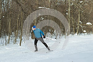 The man on the crosscountry skiing in winter forest.