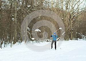 The man on the crosscountry skiing in winter forest.