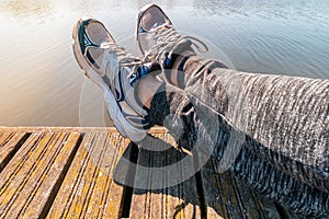 Man with crossed legs relaxing on the wooden pier