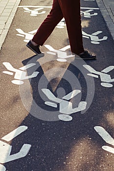 A man crosses the road in a summer park on a pedestrian crossing