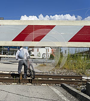 Man crosses train tracks with lowered bar