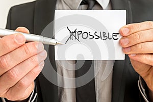 Man crossing through the Im in the handwritten word Impossible