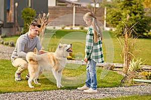 Man crouching near dog and girl looking outdoors
