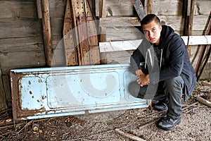 Man crouching by vintage pick up truck tailgate.