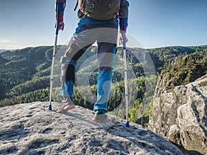 Man with crutches and strong will. Disabled tourist climb