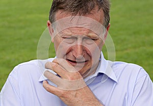 Man crying with hand up towards his face