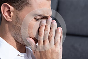 Man crying in living room at home