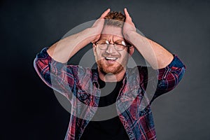 Man crying thinking why he is one who got in trouble. Whining displeased cute redhead in glasses holding hands on head