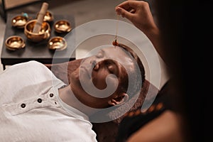 Man at crystal healing session in dark room