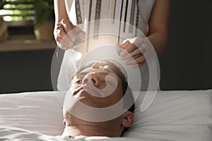 Man during crystal healing session in room