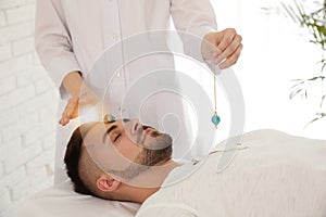 Man during crystal healing session in therapy room