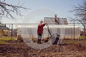 Man cultivates land with cultivator