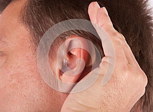 Man cupping his hand behind his ear