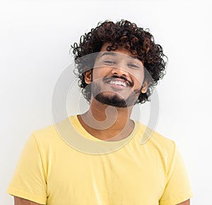 man with curly hair and happy smile. Young Indian male student smiling joyfully standing on a white background