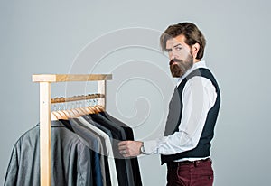Man in custom tailored suit presenting expensive tailored tuxedo. Man in boutique. Man with suit. tailor in his workshop