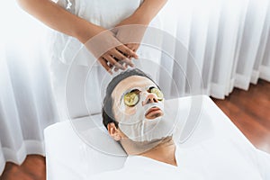 Man customer indulges in rejuvenating with cucumber facial care. Quiescent