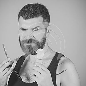 Man cut beard and mustache with razor. Haircut of bearded man, archaism.
