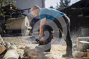 Man cut with saw. Dust and movements. Woodcutter saws tree with chainsaw on sawmill.