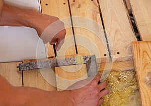 A man cuts a board with an electric saw. Repair of the floor in the house. Selective focus