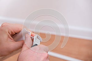 A man cuts the floor skirting boards to suitable size for installation in a room. Home renovation.