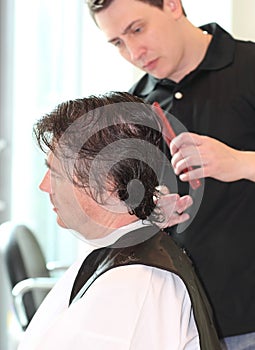 A man cuts hair in a barbershop