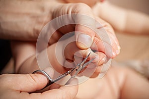 A man cuts her nails child hygiene. men`s hands hold nail scissors
