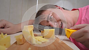 Man cuts pieces of cheese with knife on wooden cutting board, zooming in camera