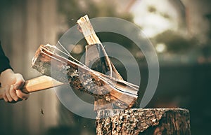 A man cuts a pine log with a sharp axe