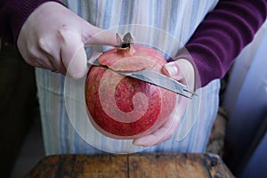 Man cuts a ripe pomegranate with a knif