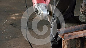 Man cuts a rusty metal beam, using a circular turbine. Angle grinder slowmotion finished work sound