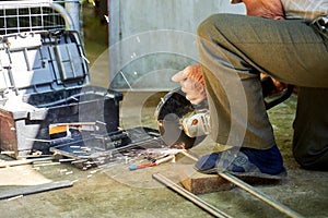 a man cuts a titanium tube with a grinder